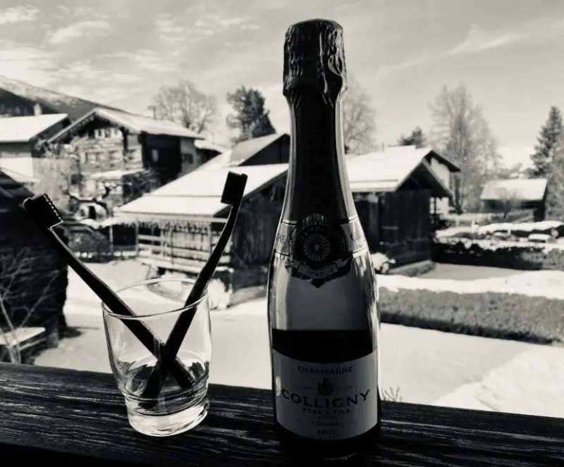 Apéritif en terrasse face aux chalets enneigés, en noir et blanc
