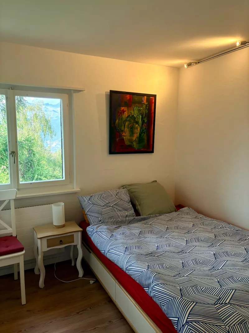 Chambre lumineuse avec lit et table de chevet