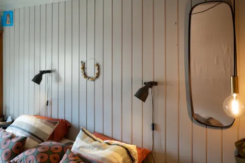 Chambre avec appliques noires, coussins et miroir