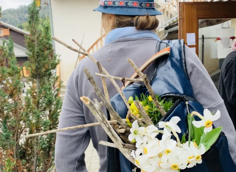 Randonneuse avec un bouquet de narcisses glissé dans son sac à dos