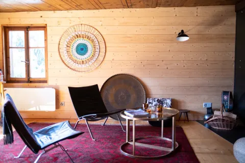 Salon lumineux avec fauteuil en cuir, table basse et plateau en laiton
