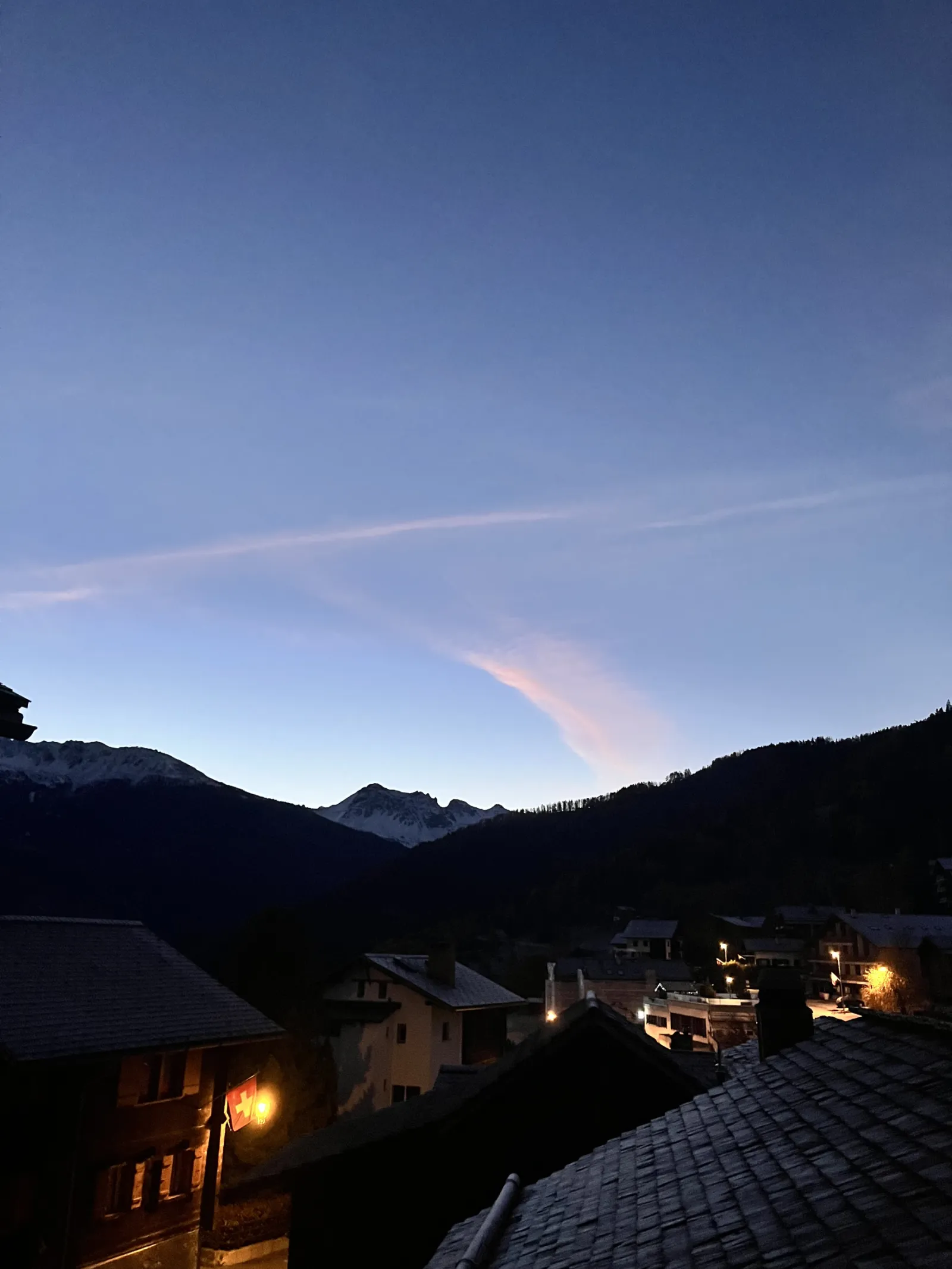 Toits du village au crépuscule face aux montagnes
