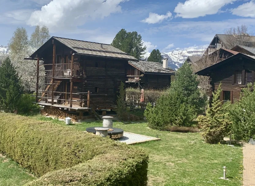 Vieux chalets en bois et jardin au cœur d'un village de montagne